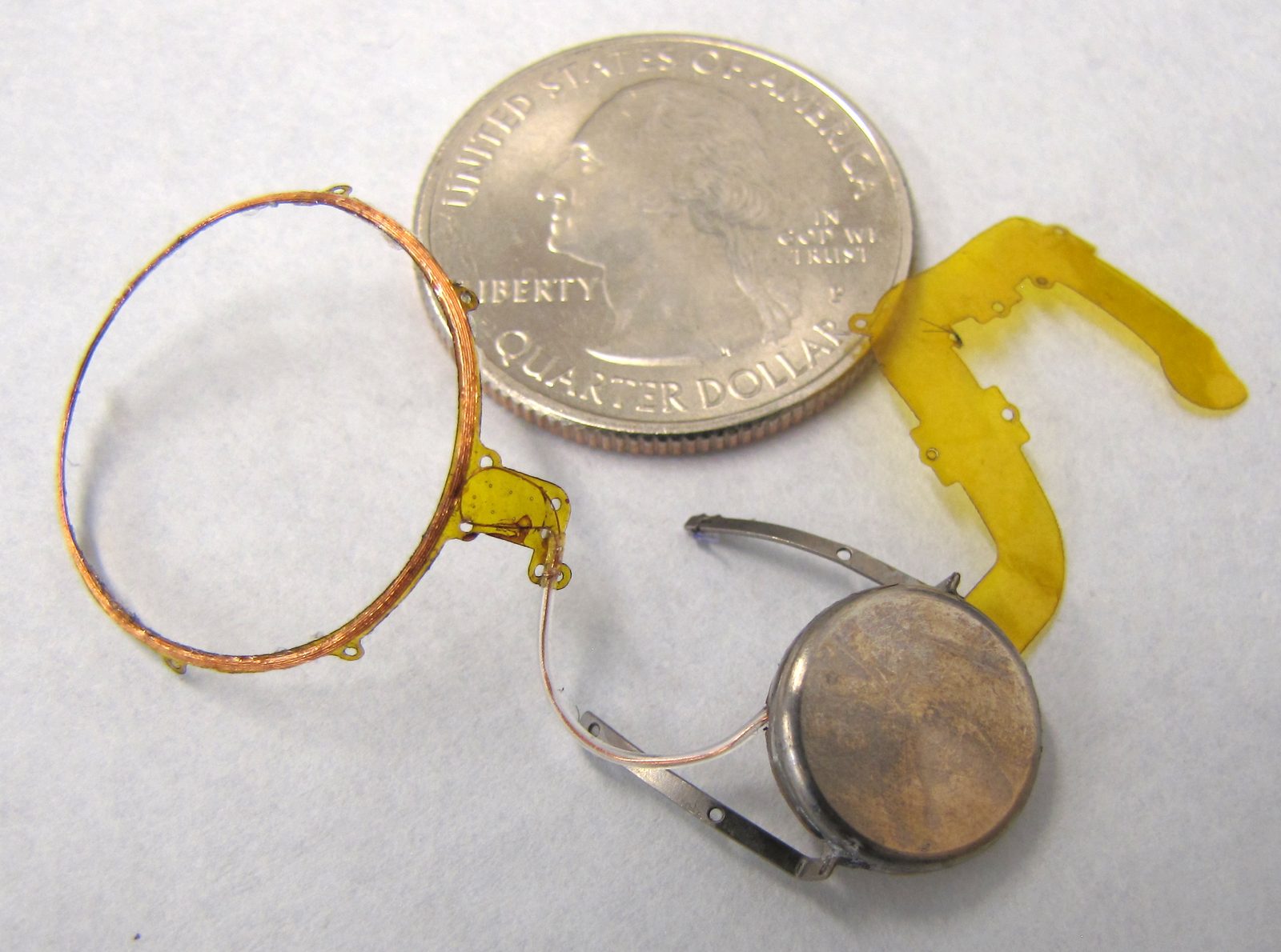 Implant components beside a US quarter (mockup)